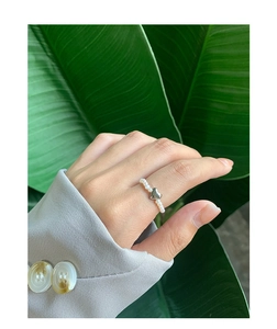Close-up of S925 silver heart charm and natural pearl beaded ring on a finger