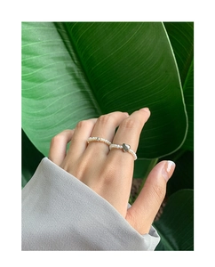 Detail of S925 silver heart charm and natural freshwater pearl beaded rings on finger
