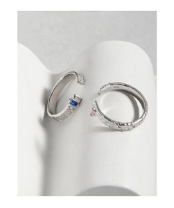 Detailed view of S925 silver rings with hammered texture and inset blue pink zircons