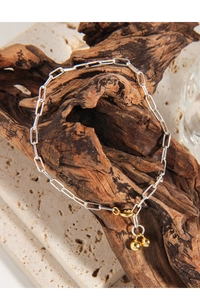 Detailed close-up of S925 silver paperclip chain bracelet with dual golden bead charms