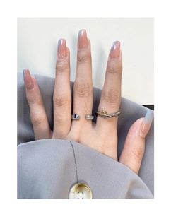 Detailed close-up of stacked silver rings featuring blue zircon and wavy minimalist design