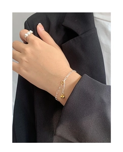 Detail showing S925 silver chain bracelet with golden beads on a model wearing a suit