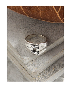 Detailed close-up of a S925 silver adjustable ring with unique cross-tie woven design