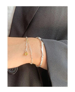 Detail of S925 silver chain bracelet with gold beads and twisted rope cuff on suit sleeve