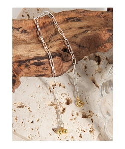 Detail of silver paperclip chain bracelet with dual gold bead charms and spring clasp