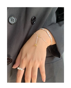 Detail of layered S925 silver bracelet and ring set with pearls on a model's hand