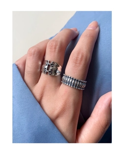 Detail of vintage S925 silver rings featuring lace-up and textured grid patterns on finger
