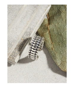 Detailed close-up of retro S925 silver ring with industrial grid pattern on stone surface