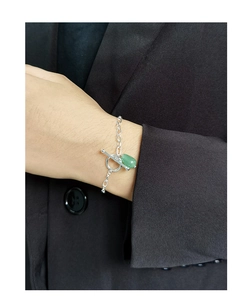 Macro detail of S925 silver bracelet featuring green jade pendant and OT clasp closure