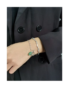 Detail of S925 silver chain bracelet with green jade teardrop pendant and cuff bangle