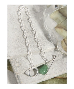 Macro shot of silver OT clasp chain with a green aventurine gemstone on stone plates