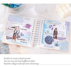 Close-up of a spiral notebook with blue and purple aesthetic stickers and collage elements