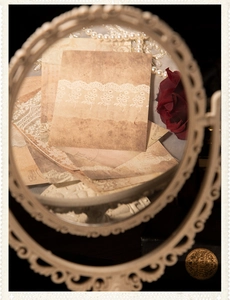 Makroaufnahme von Vintage-Scrapbooking-Papier mit Spitzenmustern und floralem Spiegelrahmen