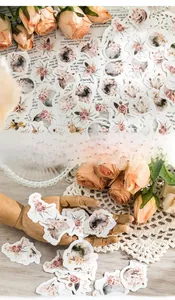 Gros plan d'autocollants de fleurs vintage et modèle de main tenant des décalcomanies