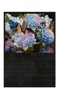 Detail of blue hydrangea and butterfly PET stickers in a woven basket for journaling