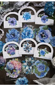 Detail of blue botanical stickers featuring roses and hydrangeas on dark wood background