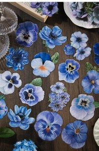 Detailed view of blue vintage floral PET stickers for scrapbooking on wooden surface