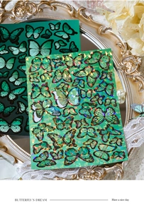 Macro detail of holographic butterfly stickers in a vintage gold decorative tray