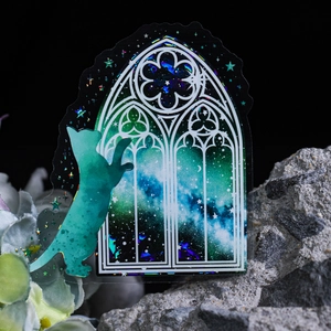 Holographic green cat sticker gazing through a gothic window with a galaxy scene