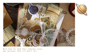 Close-up of vintage scrapbook materials featuring planets, botanicals, and maps