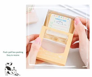 Macro detail of cat-themed acrylic stamp in a cream-orange sliding gift box