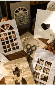 Macro view of laser-cut hollow cardstock with vintage gothic window and relief texture