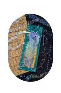 Macro view of music-themed silver laser stickers with notes and scores on a dark base