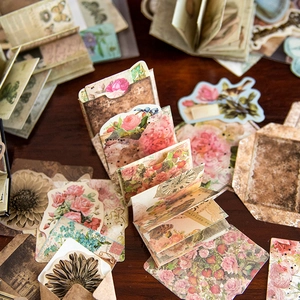 Papeles vintage para scrapbooking con mariposas y flores sobre fondo de madera oscura