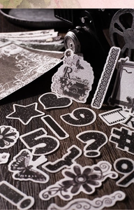 Detailed view of vintage black and white DIY stickers with retro aesthetic on wood