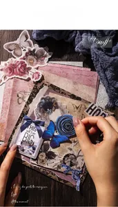 Detail view of vintage scrapbooking stickers with butterflies and roses on wood desk