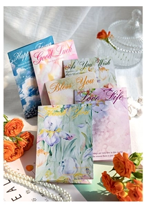 Detailed view of floral greeting cards with gold foil lettering and watercolor designs