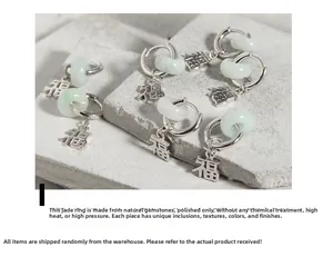 Detail of silver S925 earrings with green jade rings and Chinese Fu character charms