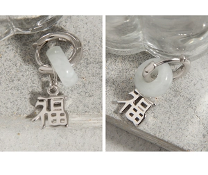 Detail of S925 sterling silver stamp and Fu character charm on green jade earrings
