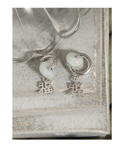 Close-up of S925 silver earrings with jade-style ring and Fu character pendant