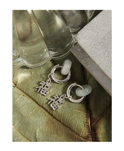 Macro detail of S925 silver earrings with jade hoops and Fu character charms