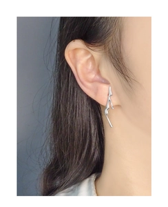 Macro shot of S925 silver liquid metal earrings with irregular lava design on ear
