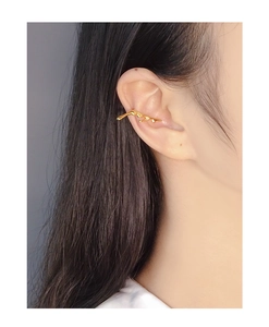 Detailed view of irregular liquid lava ear cuff in polished gold finish on model