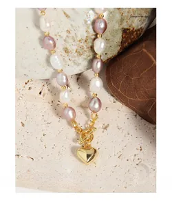 Detailed macro shot of baroque pearl necklace with golden heart pendant and OT clasp