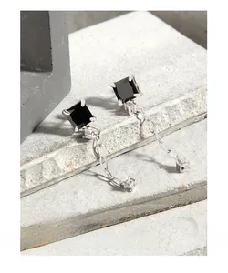 Détail de la boucle d'oreille en argent S925 avec pierre noire carrée et fine chaîne