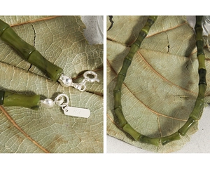 Détail du fermoir en argent S925 et du collier de jade en forme de bambou sur une feuille