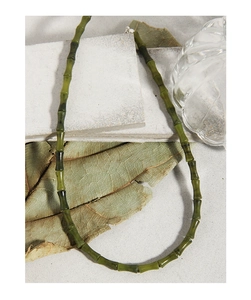 Détail des perles de jade vert style bambou sur une chaîne en argent sterling S925