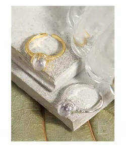 Detail of gold and silver irregular textured rings with claw-set round zircon stones