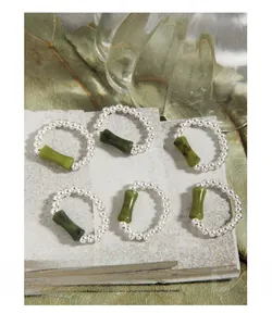 Close-up of S925 silver beaded rings featuring green bamboo-shaped gemstone accents