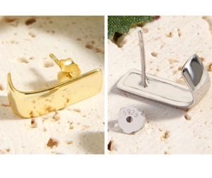 Macro shot of minimalist geometric S925 sterling silver stud earrings in gold and silver