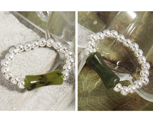 Macro shot of S925 silver beaded ring with a green bamboo jade pendant detail