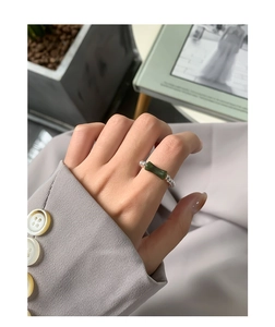 Detail of S925 silver beaded ring with green bamboo-shaped gemstone on a model's hand