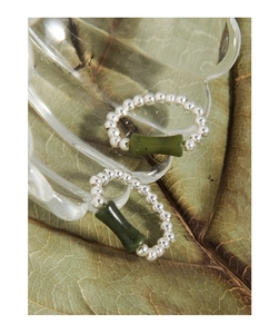 Macro detail of S925 silver beaded rings with green bamboo-shaped jadeite centerpieces