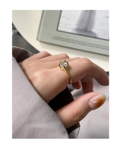 Macro detail of gold S925 silver ring featuring geometric pleated texture and zircon stone