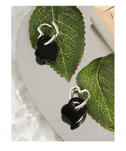Macro shot of S925 sterling silver stamp on minimalist black heart-shaped earrings