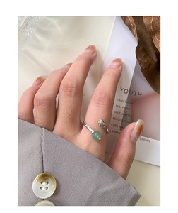 Detail of S925 silver ring with wrinkled texture and green aventurine on index finger